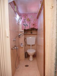 a bathroom with a toilet with flowers on the wall at Η Φωλιτσα in Karpenision