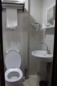 y baño con aseo blanco y lavamanos. en KONAK HOTEL 2, en Kars