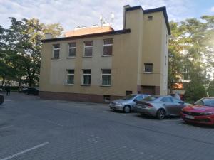 two cars parked in front of a building at Hostel KASZUBSKA in Wrocław
