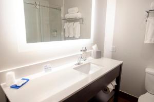 a white bathroom with a sink and a mirror at Holiday Inn Express Marshfield - Springfield Area by IHG in Marshfield +10 photos