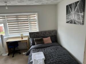 1 dormitorio con cama, escritorio y ventana en Alder en-suite self catering with private shower 3, en Southampton