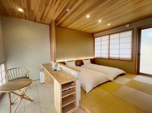 een slaapkamer met een bed, een bureau en een stoel bij Kansai Airport Pine Villa in Kansai International Airport