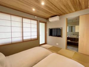 Habitación con cama y TV. en Kansai Airport Pine Villa, en Kansai International Airport