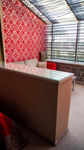 Habitación con sofá y pared roja. en Boutique Spa Casino Hotel Lybid Plaza en Khmelʼnytsʼkyy