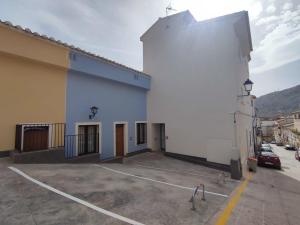 een wit gebouw met een parkeerplaats ervoor bij Parador 10 Apartamentos in Cehegín