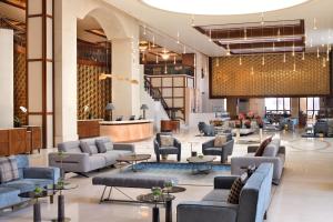 Crowne Plaza - Dubai Jumeirah, an IHG Hotel في دبي: لوبي فندق فيه كنب وطاولات