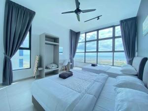 a bedroom with two beds and a large window at Atlantis Residences Melaka by HeyStay Management in Melaka