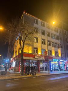 un grupo de personas sentadas fuera de un edificio por la noche en KONAK HOTEL 2, en Kars