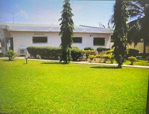 a white house with a yard with green grass at Exclusive Holiday Villa with Pool in Accra in Accra