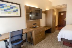 a hotel room with a desk and a bed at Holiday Inn Express Marshfield - Springfield Area by IHG in Marshfield