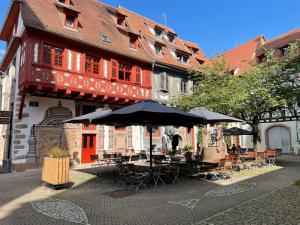a patio with tables and umbrellas in front of a building at Ibis Budget Sélestat in Sélestat