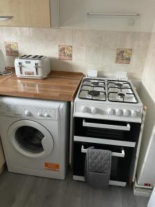 a kitchen with a stove and a washing machine at Alder en-suite self catering with private shower 3 in Southampton