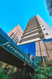 a hotel sign in front of a tall building at Ferraretto Guarujá Hotel & Spa in Guarujá