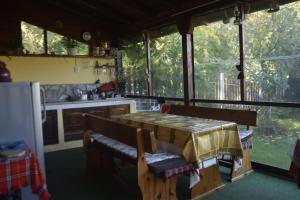 una cocina con mesa y algunas ventanas. en Guest House Zdravets, en Sapareva Banya