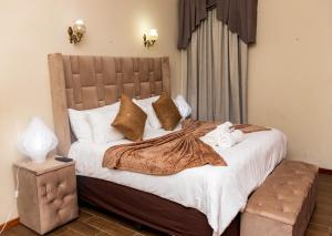 1 dormitorio con 1 cama grande con sábanas y almohadas blancas en CONSTANTIA GUEST LODGE, en Pretoria