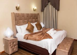 a bedroom with a large bed with white sheets and pillows at CONSTANTIA GUEST LODGE in Pretoria