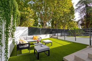 a patio with a couch and tables on grass at Genteel Home Arruzafa in Córdoba