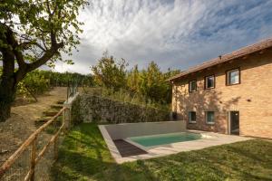 einem externen Blick auf ein Haus mit einem Pool in der Unterkunft Borgo Roggeri - Country House nelle Langhe in La Morra