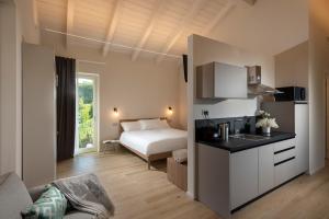 a bedroom with a bed and a kitchen with a sink at Borgo Roggeri - Country House nelle Langhe in La Morra