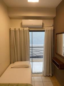 a bedroom with a bed and a window with a view at Marge Hotel in Aparecida