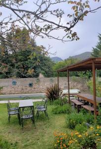 a picnic table and chairs in a garden at Posada de la Montaña in La Cumbre
