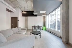 ein Wohnzimmer mit einem Sofa und einem Tisch in der Unterkunft Initial / Yogi+ Parking / Centre-Ville de Québec in Québec