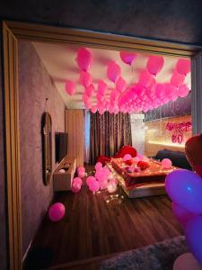 una habitación con globos rosas colgando del techo en MIS HOSTEL Cần Thơ en Can Tho
