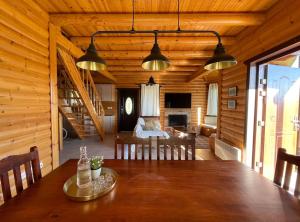 un comedor con una mesa en una cabaña en Chalet Klimatia - Όμορφη ξύλινη μεζονέτα με τζάκι 