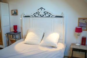a white bed with a white headboard and two pillows at La Aussière, Maison avec jardin à 500m de la plage pour 4 à 6 pers in Cayeux-sur-Mer