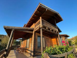 a log cabin with a porch and a deck at Chalet Klimatia - Όμορφη ξύλινη μεζονέτα με τζάκι 