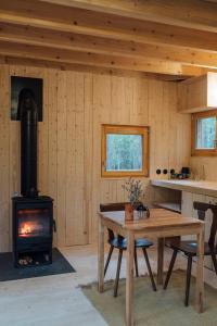 uma cozinha com um fogão a lenha numa sala com uma mesa em Youza ecolodge em La Couture-Boussey