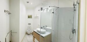 biała łazienka z umywalką i prysznicem w obiekcie B&B in Redondo Residence w Lizbonie