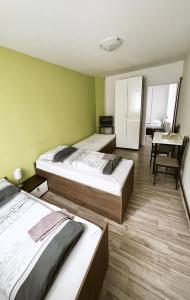 2 camas en una habitación con escritorio y mesa en Penzion Zahrádka en Lázně Bohdaneč