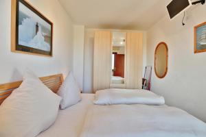 een slaapkamer met 2 witte bedden en een spiegel bij Haus Strandallee 24 Haus Strandallee 24 - Appartement Seemanns Meeresblick in Scharbeutz