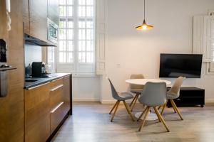 cocina con mesa y sillas en una habitación en Casa Palacio La Casa Blanca Suites, en Sevilla