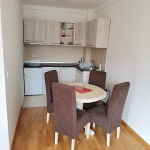 a kitchen with a table and chairs in a room at Apartman Lea & parking u garaži in Soko Banja