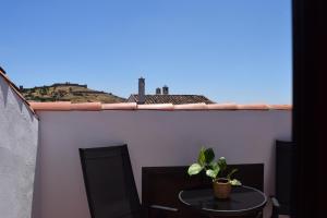 a table and two chairs on a balcony with a plant at Hostal Rural Molino Del Bombo in Aracena