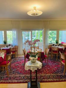 a restaurant with tables and chairs and a vase of flowers at Design-Boutique Hotel Vosteen in Nuremberg
