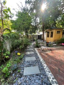 einen Garten mit einem Backsteinsteg und einer Bank in der Unterkunft Design-Boutique Hotel Vosteen in Nürnberg