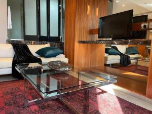 a living room with a glass coffee table and a tv at Apartment on 8th in Johannesburg