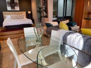 sala de estar con sofá y mesa de cristal en Apartment on 8th, en Johannesburgo