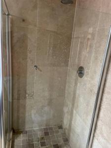 a shower with a glass door in a bathroom at Apartment on 8th in Johannesburg