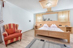 um quarto para crianças com uma cama e uma cadeira em Alpen Living - 2 Stock em Cadipietra