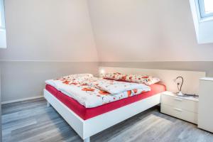 a white bedroom with a bed with orange and white sheets at Alpen Living - 2 Stock in Cadipietra +12 photos