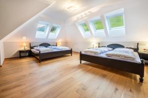 two beds in a attic room with skylights at Alpen Living - 2 Stock in Cadipietra