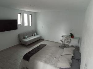 Biały salon z łóżkiem i kanapą w obiekcie Habitación Platino comfort y elegancia en Pachuca 