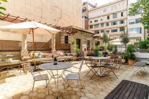 a patio area with tables, chairs and umbrellas at Casa Gracia in Barcelona