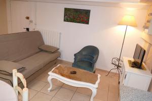 een woonkamer met een bank en een salontafel bij Appartement avec véranda donnant sur le jardin in Le Pontet