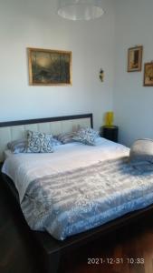Cama grande en habitación con pared blanca en Casa Vacanze LELUPE en Sant'Agnello