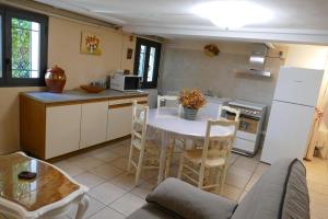 een keuken met een witte tafel en een witte koelkast bij Appartement avec véranda donnant sur le jardin in Le Pontet